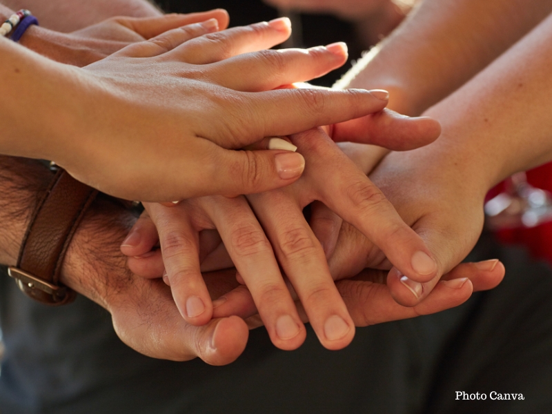 Des mains qui s'empilent les unes sur les autres pour symboliser la solidarité de cette nouvelle newsletter de la ligue, à 4 voix. Un pour tous et tous pour vous ! Image Canva